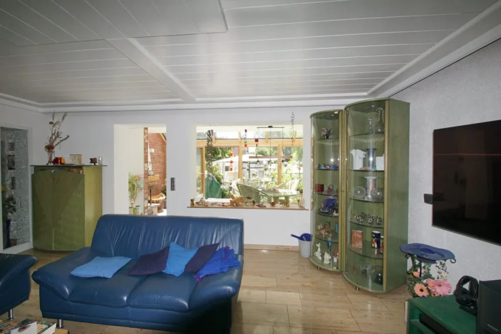 Blick vom Wohnzimmer durch das Fenster in den Wintergarten Ahorntal