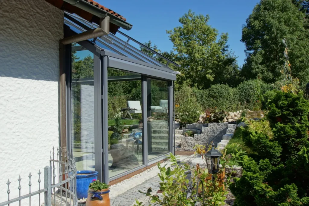 Seitenansicht des Wintergartens Bayreuth mit Schiebetür und schiefergrauen Profilen
