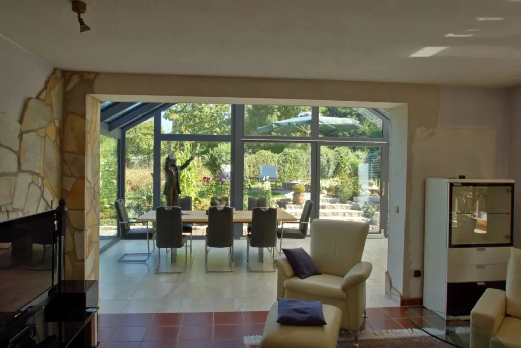 Blick aus dem Wohnzimmer in Bayreuth durch die geöffnete Außenwand in den Wintergarten