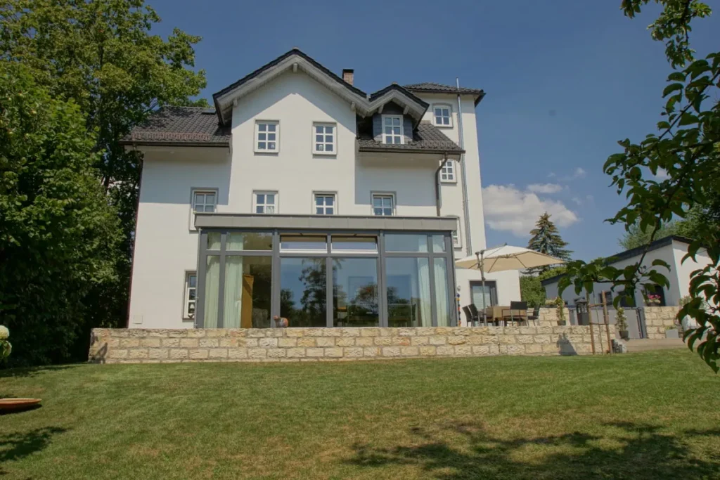 Gartenseite der Villa in Coburg mit dem Anbau und Natursteinmauer