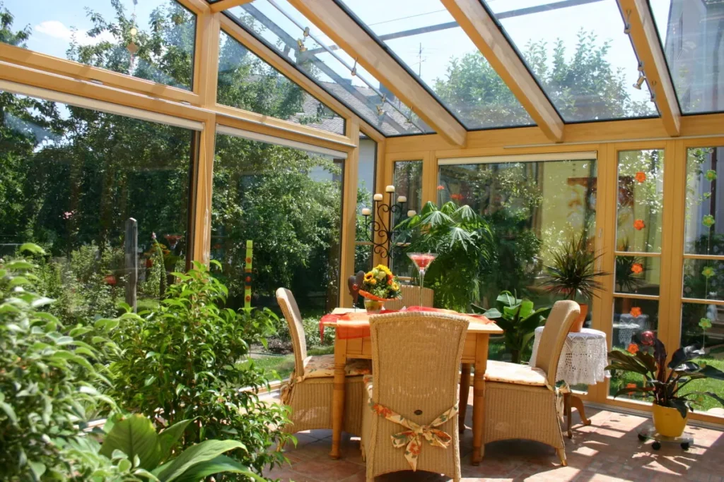 Wohnwintergarten in Dechsendorf von innen: Esstisch und Pflanzen unter dem Holzdach