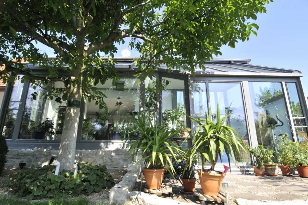Wohnwintergarten in Kleinsendelbach zwischen Obstbäumen, von außen